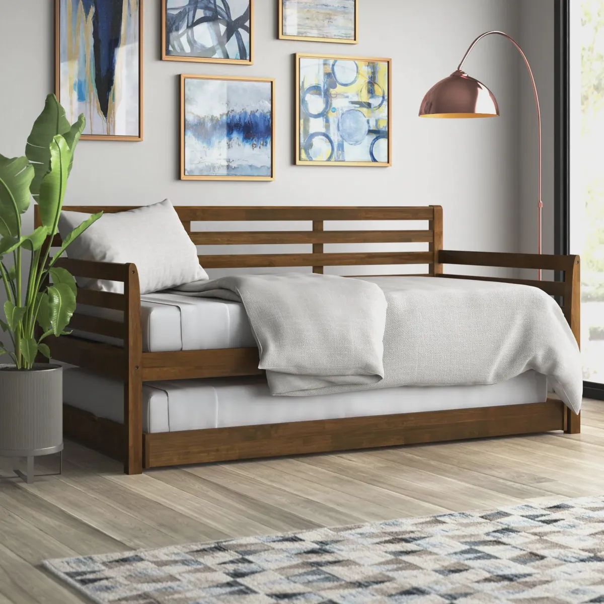 Wooden daybed with a pop-up trundle raised to bed height, ready for an adult guest