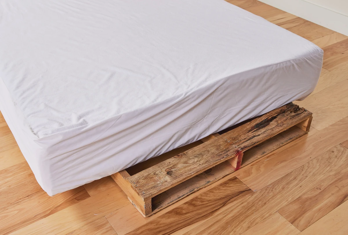 A couple lifting a mattress to move it out of storage