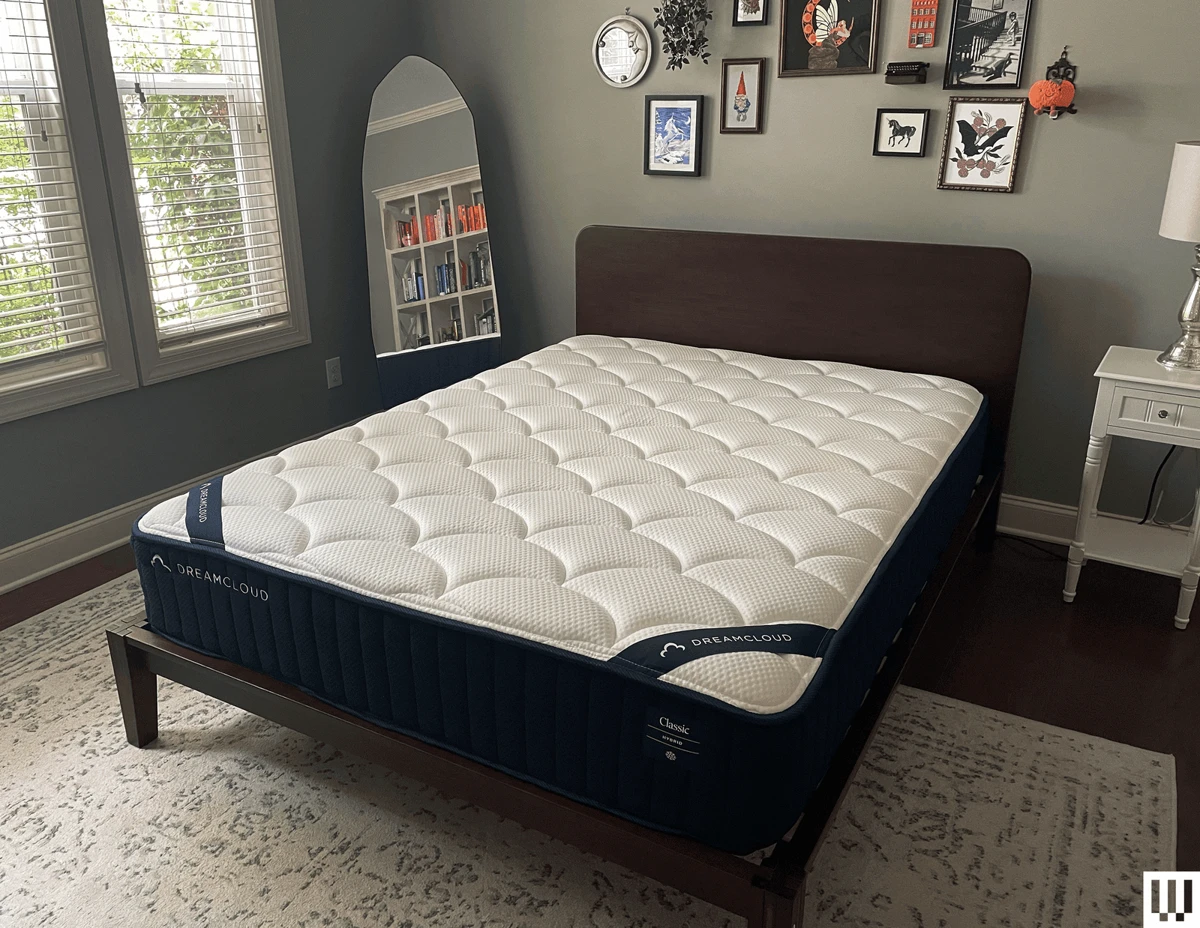 DreamCloud Classic Hybrid mattress from the side showing quilted cover, comfort foam layers, and pocketed coil base