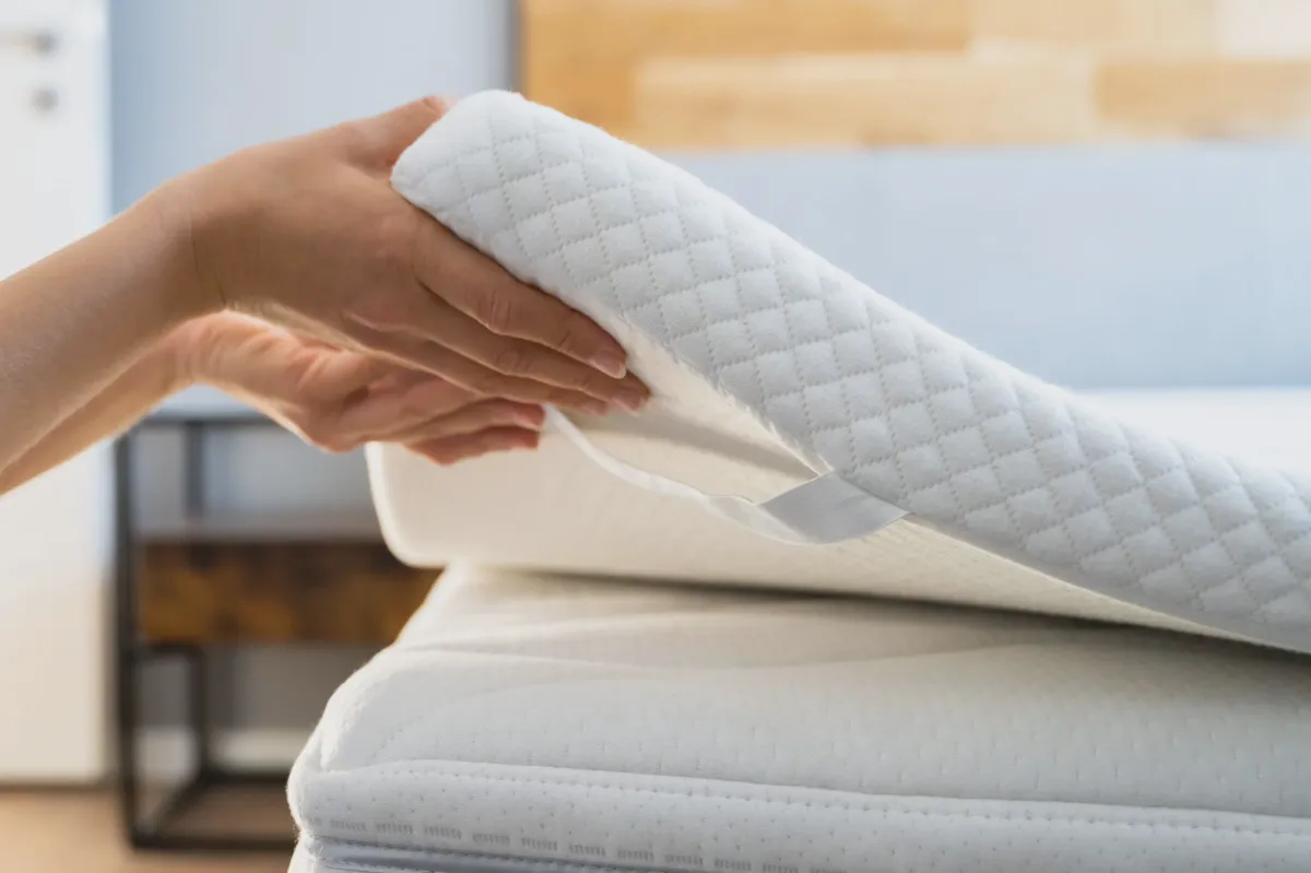 Electric carving knife slicing cleanly through a memory foam mattress topper