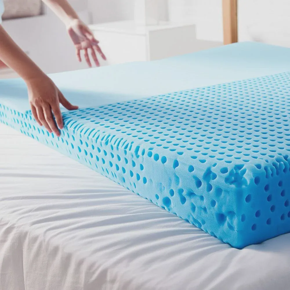 Memory foam mattress topper unrolled on a bed