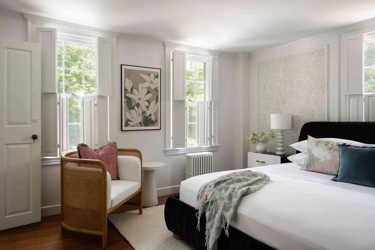 Bedroom with platform bed frame surrounding an adjustable base, with a bench at the foot