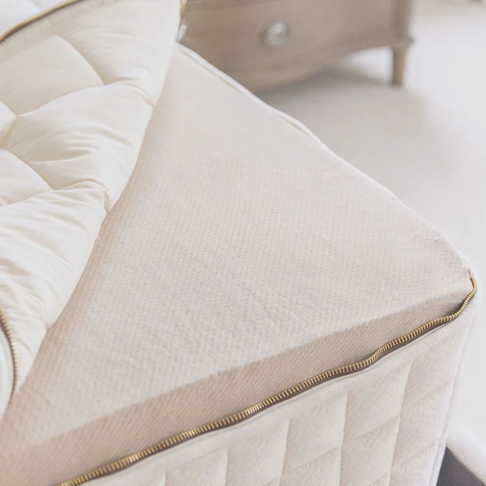 Cutaway of the Naturepedic EOS organic mattress showing organic cotton cover, wool batting, latex layer, and pocketed-coil base