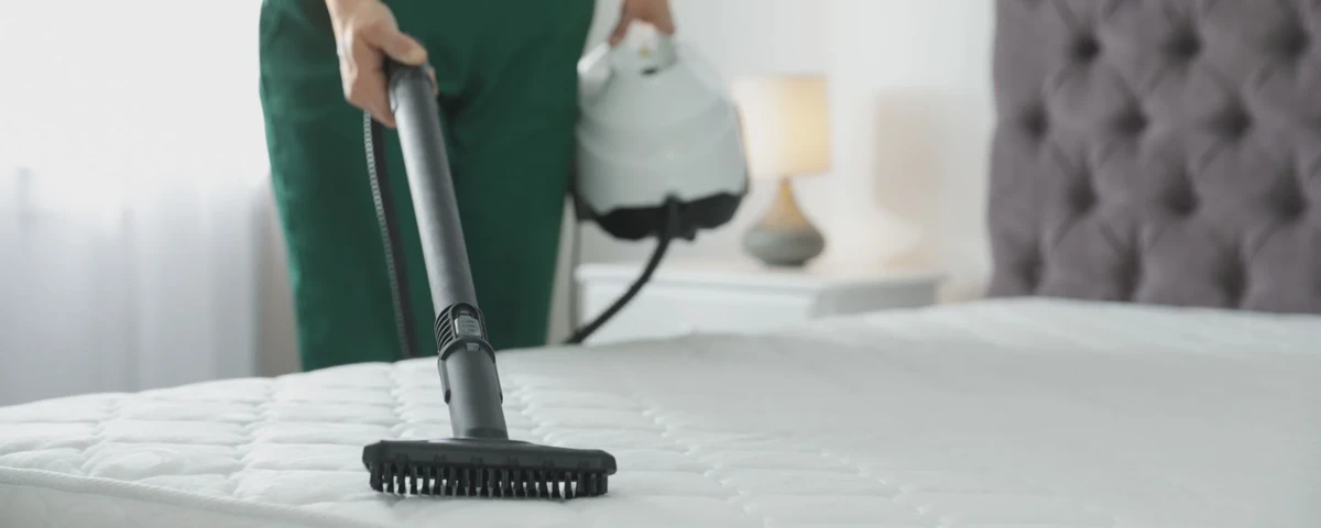 Baking soda being sprinkled across the surface of a mattress
