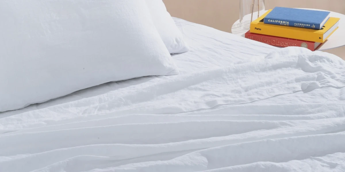 Crisp white bed sheets on a made bed
