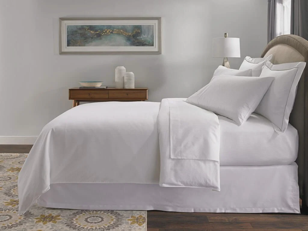 Hotel bed made with bright white sheets