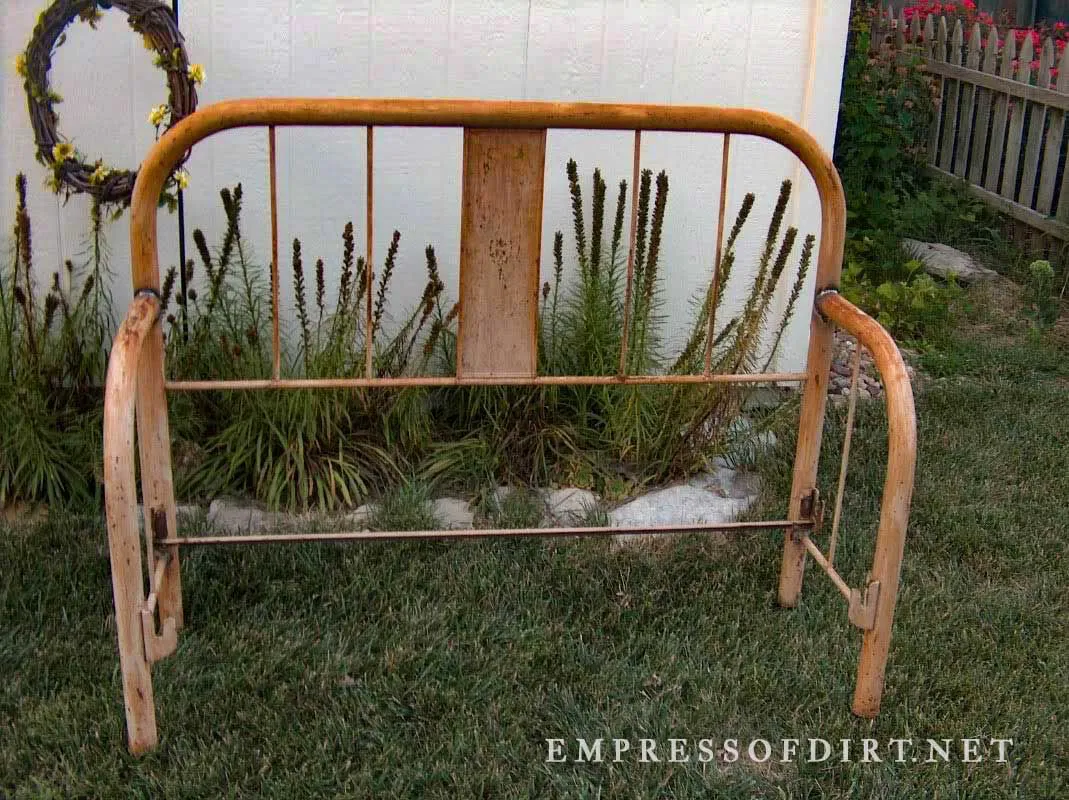 Old metal bed frame repurposed into a garden bench