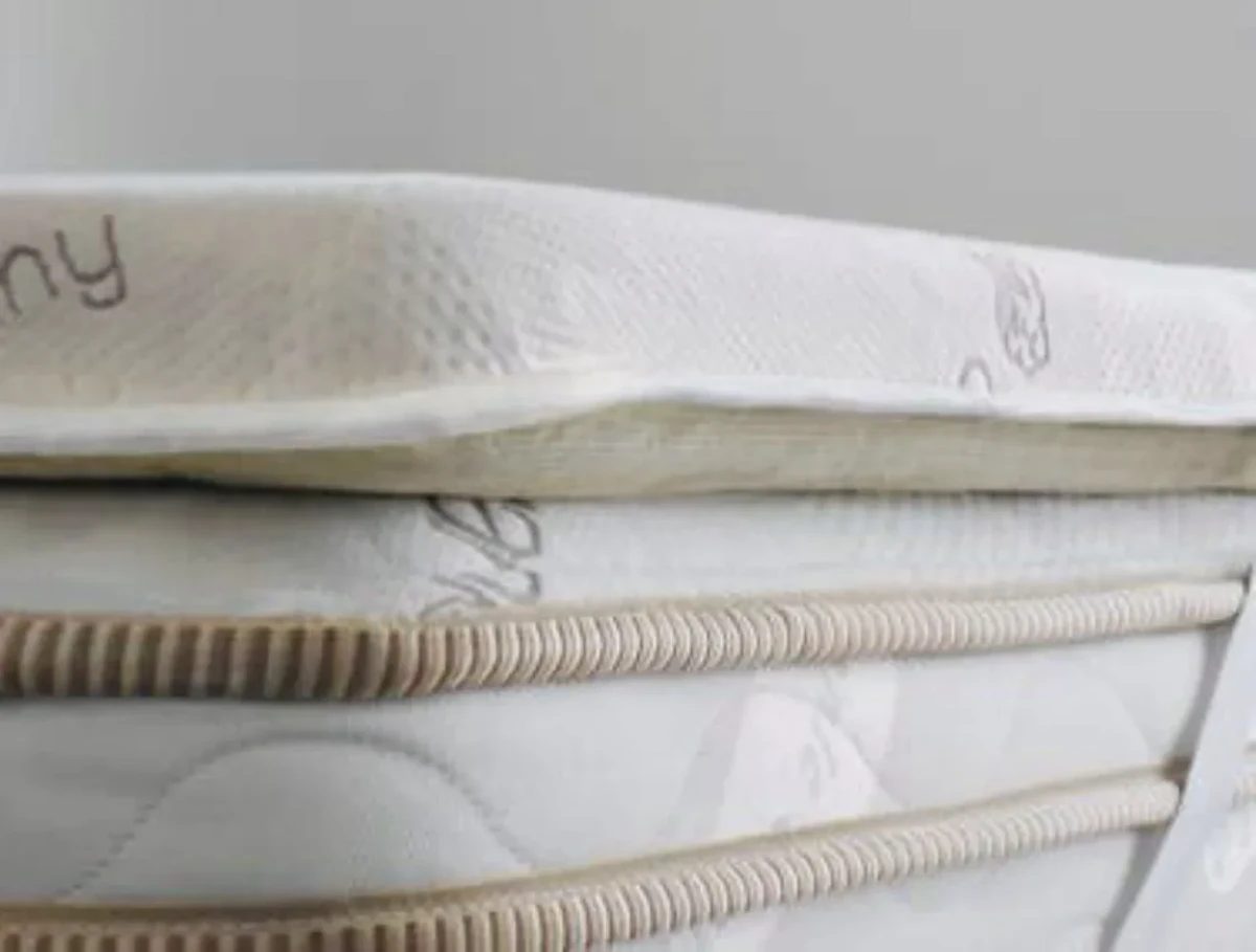 Tester evaluating a memory foam mattress topper