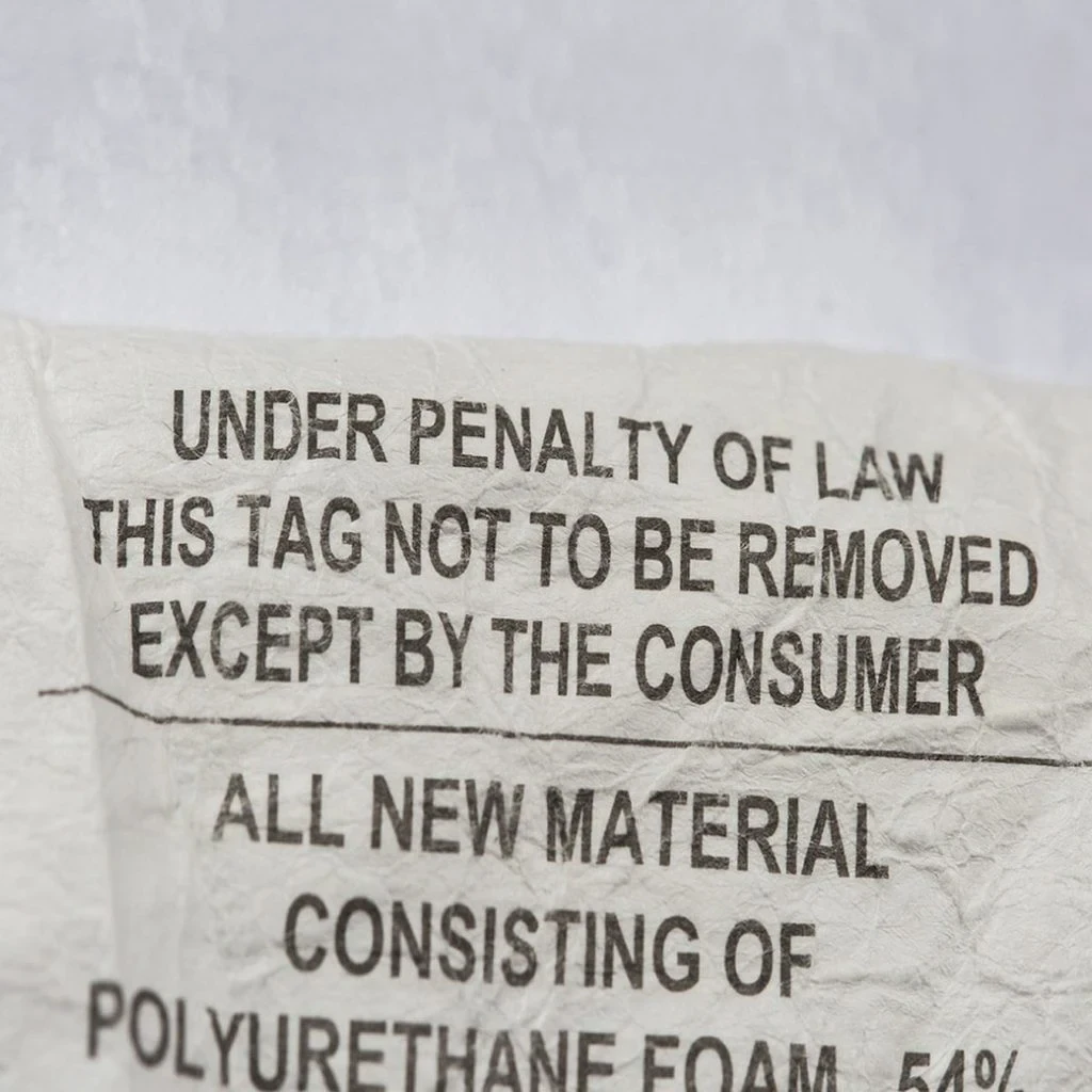 Mattress law tag close-up showing required disclosures