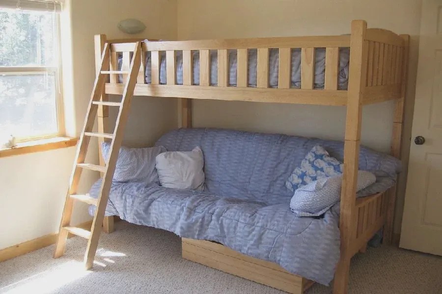 Adult guest sitting on the lower trundle pull-out bed