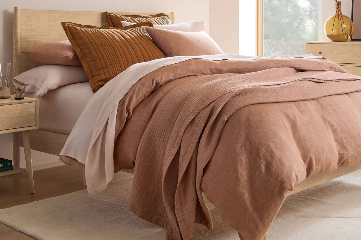 Linen cooling blanket on a bed in a bright bedroom