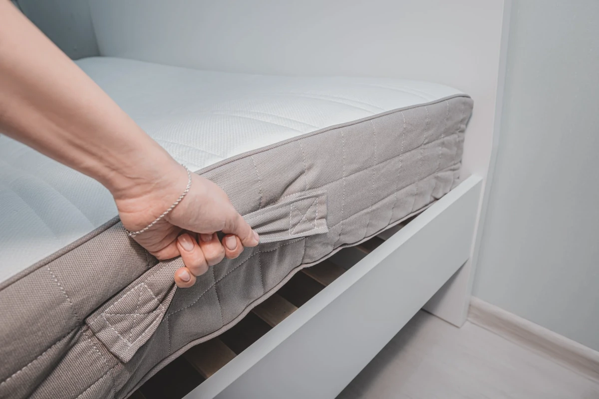 Reinforced turning handles sewn into the side of a flippable mattress
