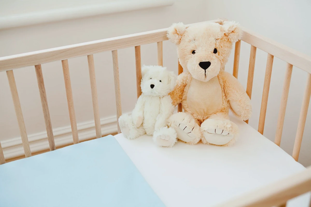 Wiping a baby mattress pad with a damp microfiber cloth