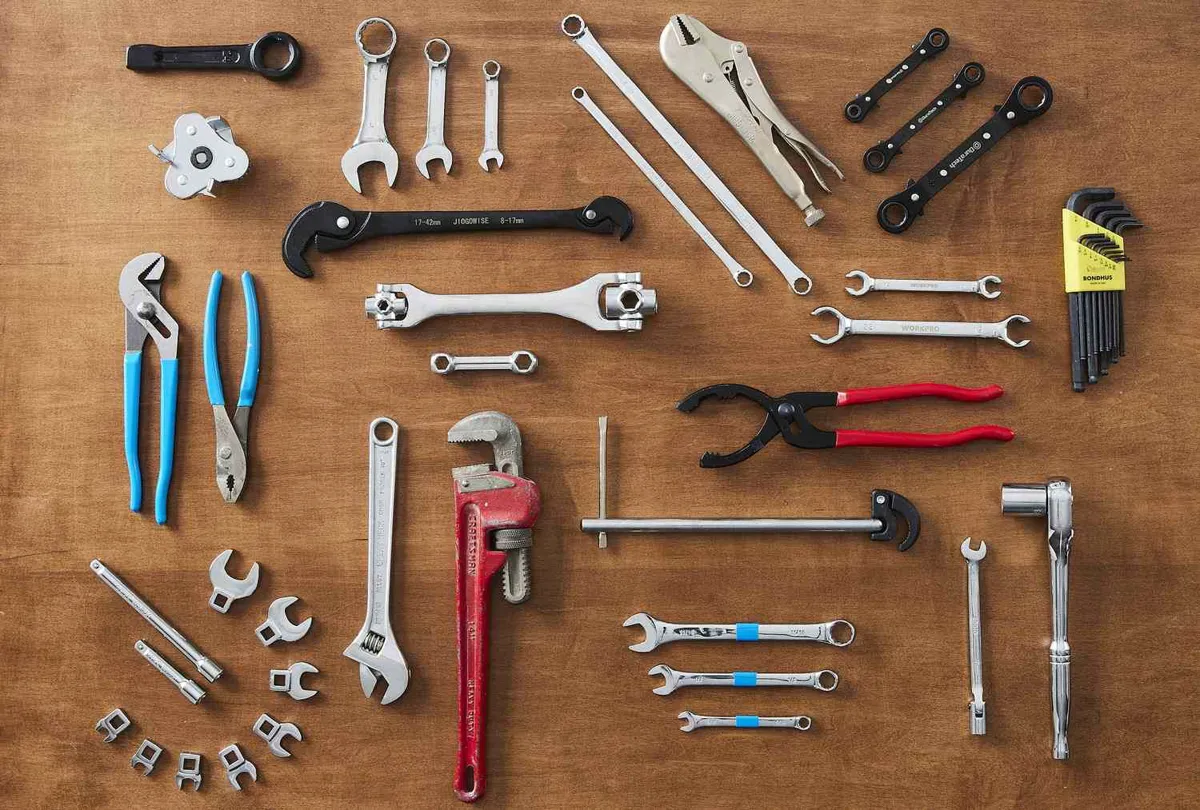 Adjustable wrench and socket tools laid out on a workbench