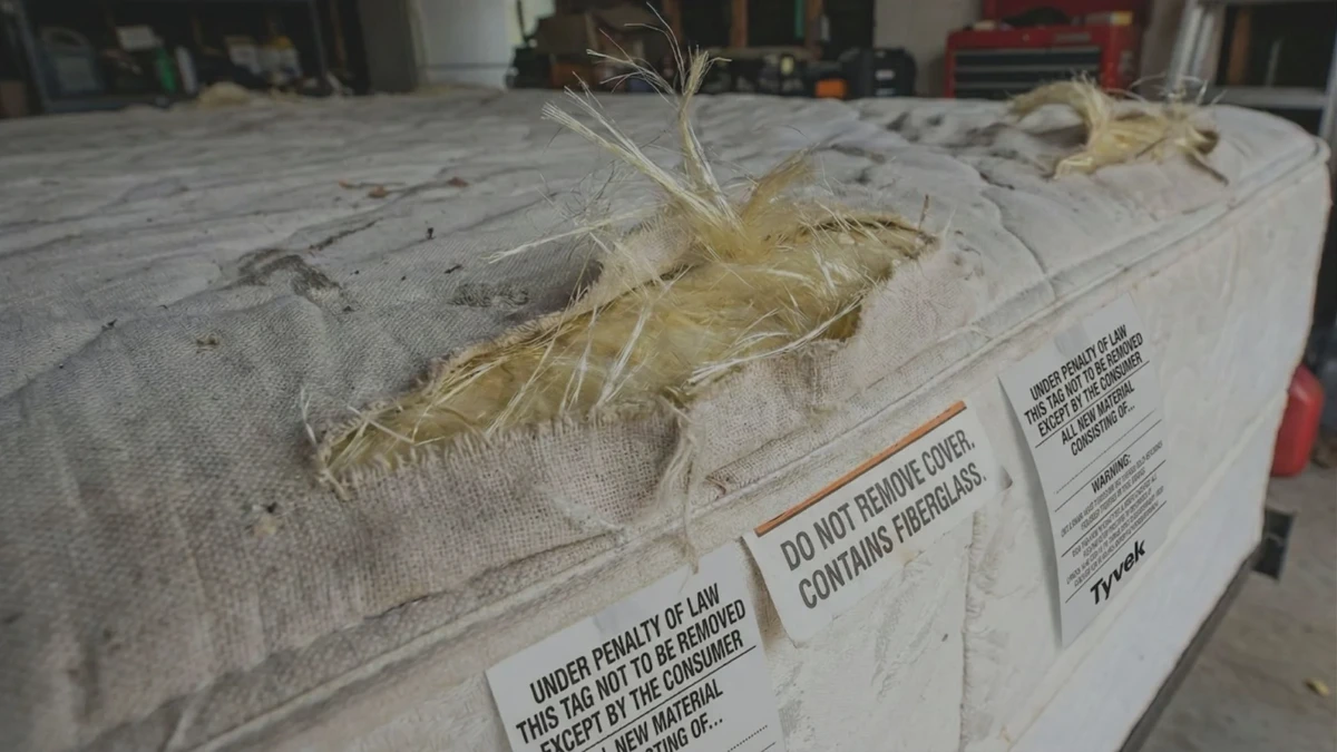 Loose fiberglass strands on a budget memory foam mattress cover
