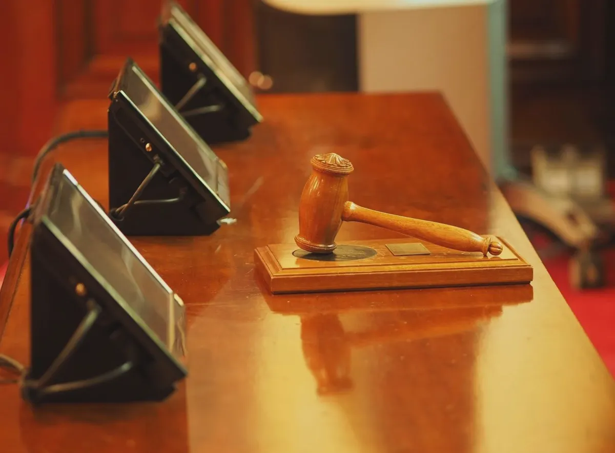 Judge's gavel and tablet on a courtroom desk