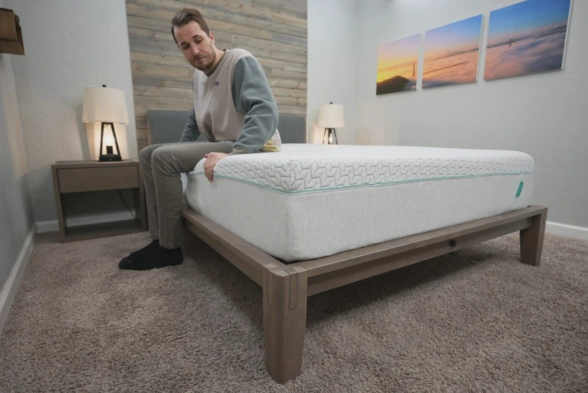 A reviewer demonstrating edge compression on the perimeter of the Tuft & Needle Original mattress