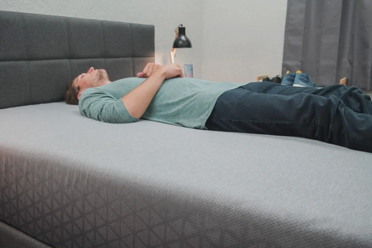 Back sleeper lying on a Zoma Hybrid mattress to test spinal alignment