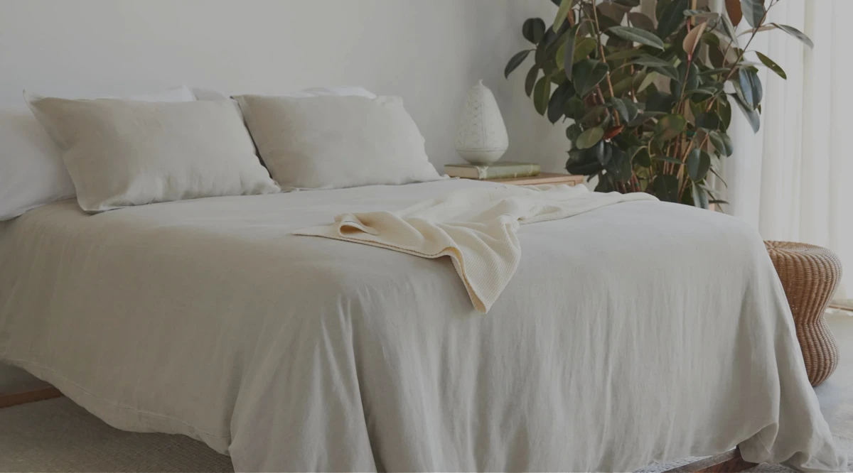 Bedroom with organic cotton bedding folded on a wooden bench