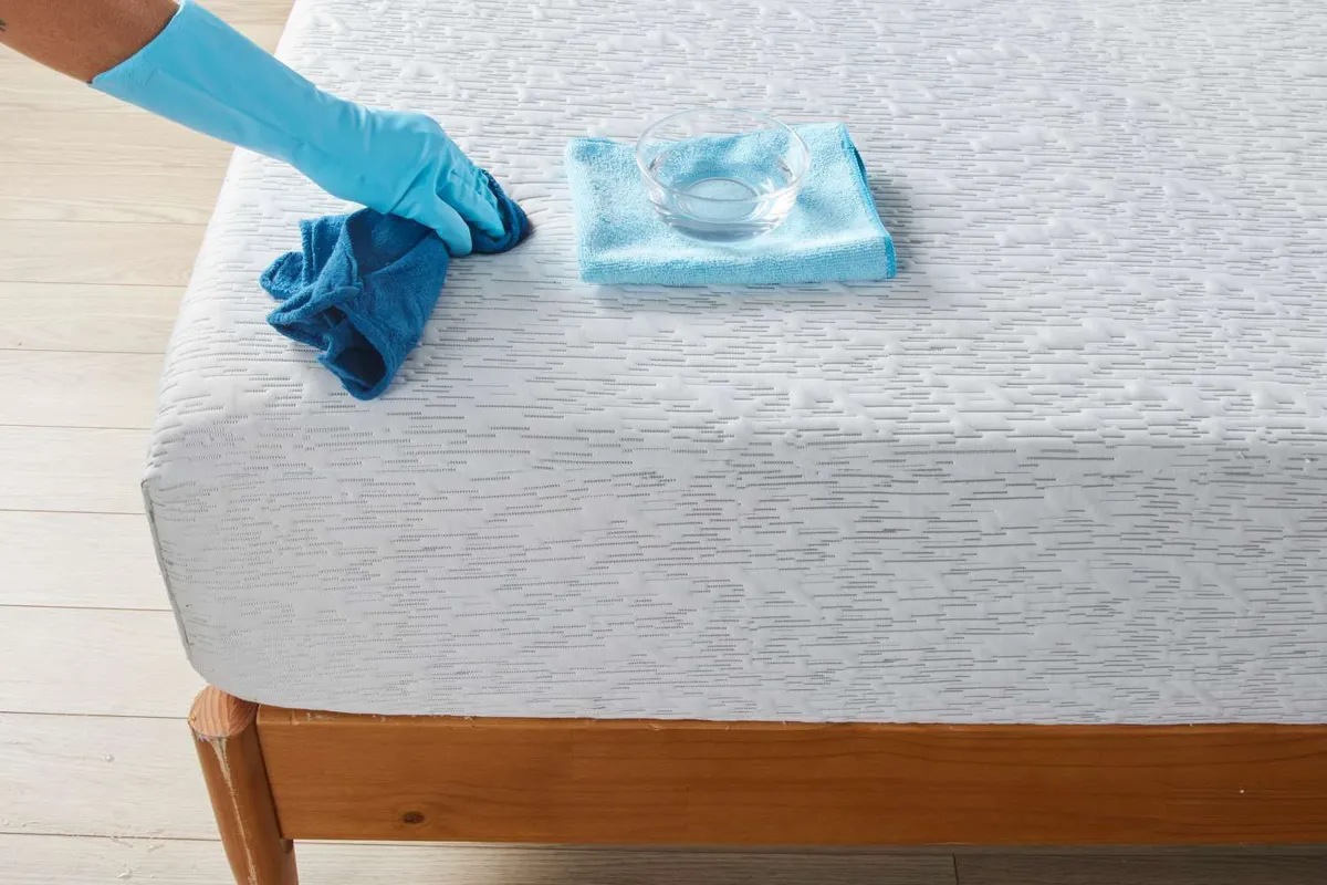 Spraying a homemade hydrogen peroxide and dish soap solution onto a mattress stain