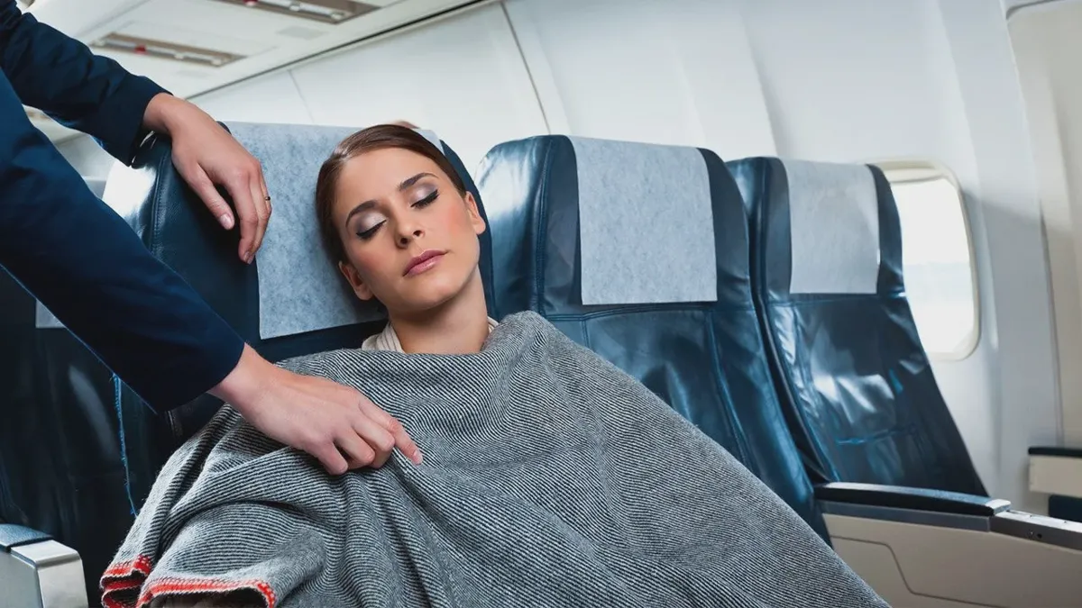 Folded blanket waiting on an airline seat before takeoff